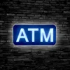 LED ATM Sign lit up against a black brick wall for retail businesses with ATMs.