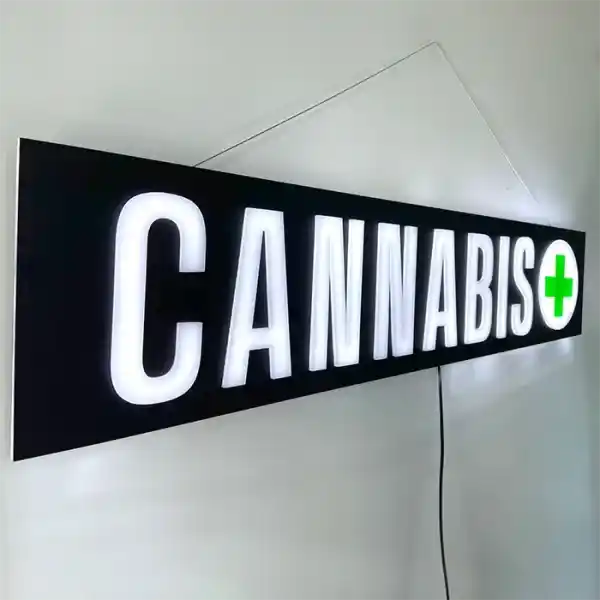 Smoke shop and Cannabis Dispensary Cannabis Pot leaf LED Retail ready sign against a white wall lit at an angle
