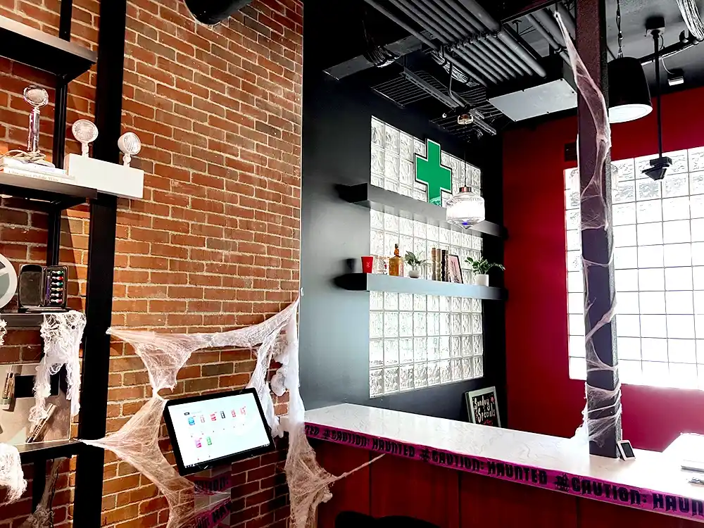 Halloween decorated Chicago Cannabis dispensary with a stapleGreen Cross weed LED sign