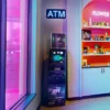 Mobile Moiney machine being illuminated by ATM signage inside of an Illinois marijuana dispensary store next to a cannabis flower display.