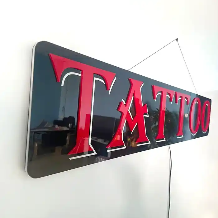 Tattoo LED Retail ready sign against a white wall not lit at an angle