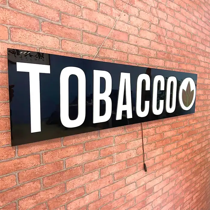 Tobacco LED sign against a red brick wall not lit