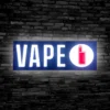 Lit up Vape LED sign mounted on a black brick wall