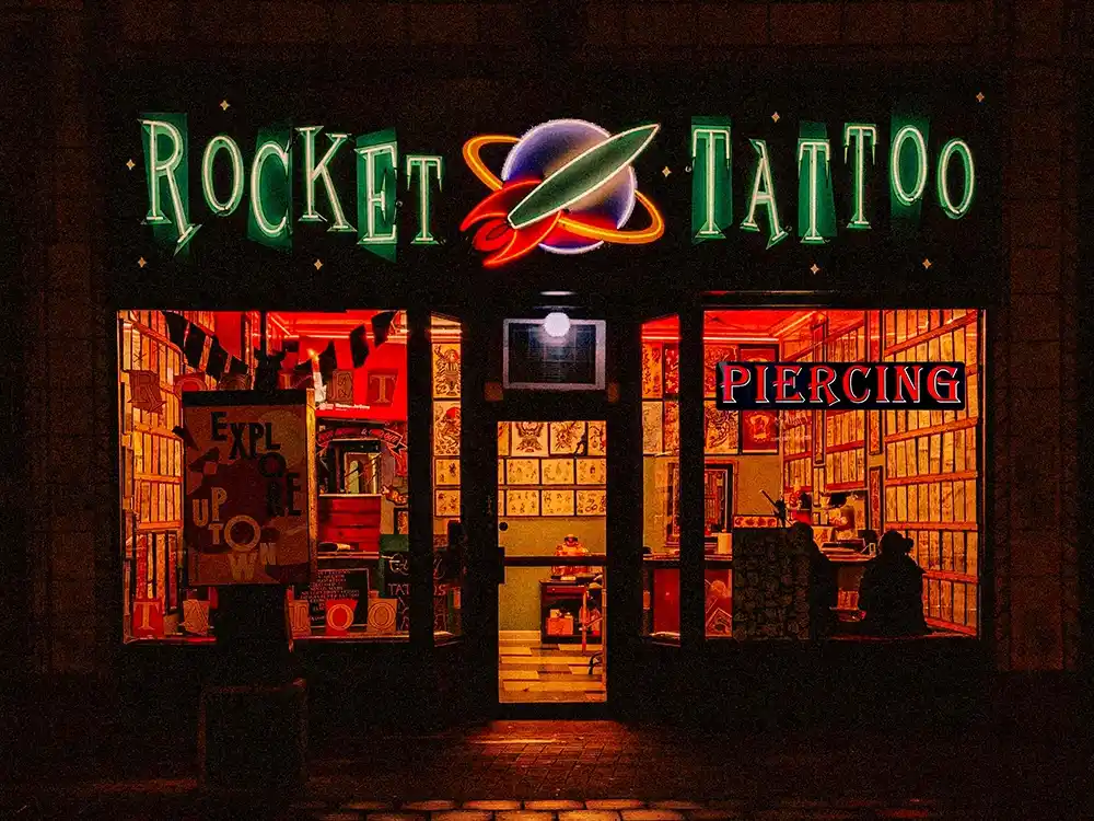 window storefront displaying Tattoo Parlor LED Shop sign lit at night